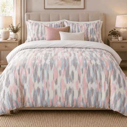 Blush Blue Ikat duvet cover set, front view showing pink, blue and grey ikat streaks on a tufted bed