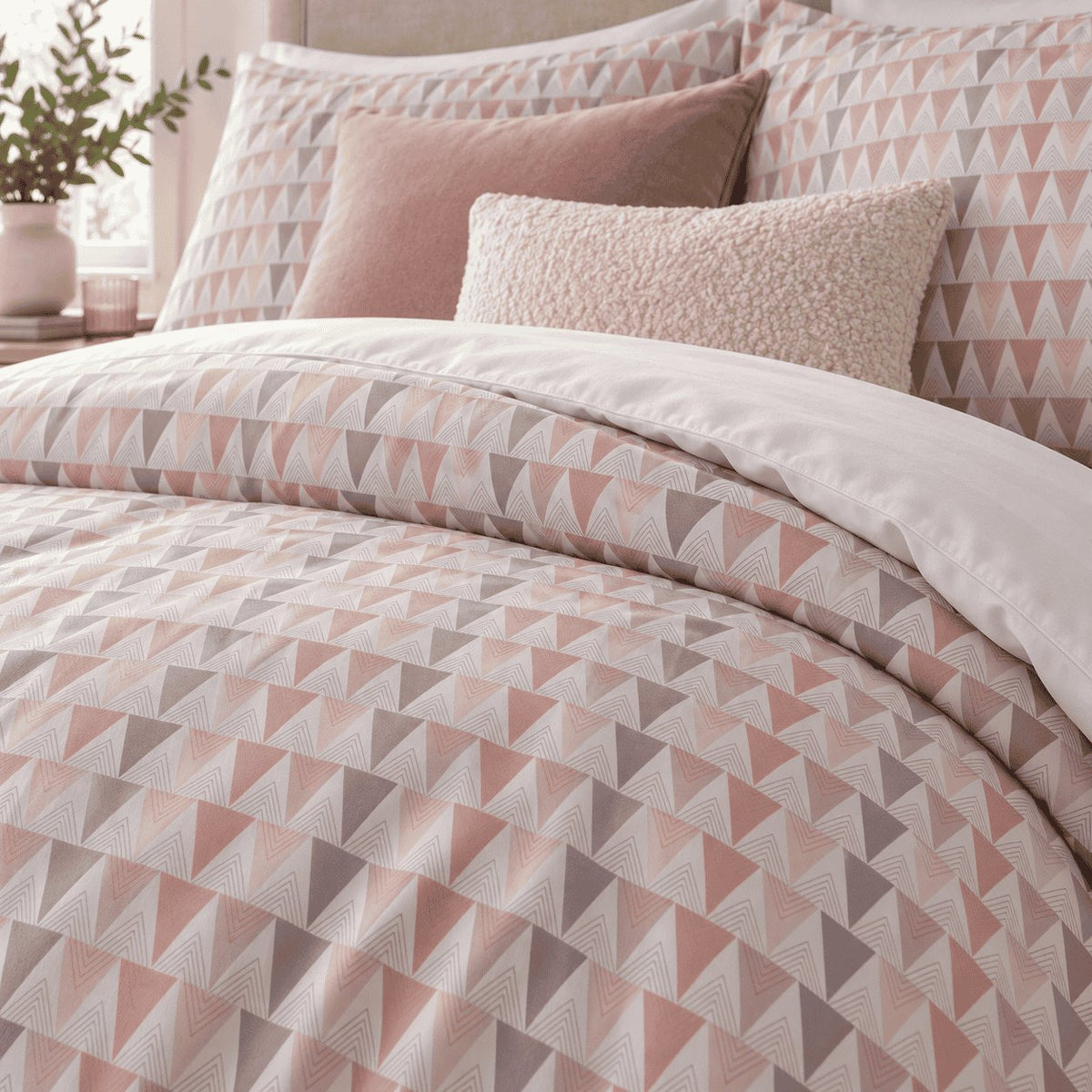 Blush Grey Triangle duvet cover set, close-up of pillowcases showing pillowcases behind pink velvet and cream cushions