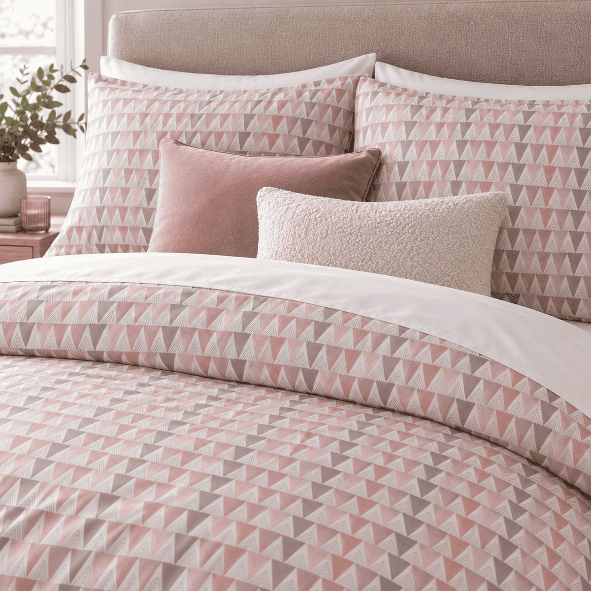 Blush Grey Triangle duvet cover set, close-up of print showing blush, rose and grey triangles beside white chevron triangles