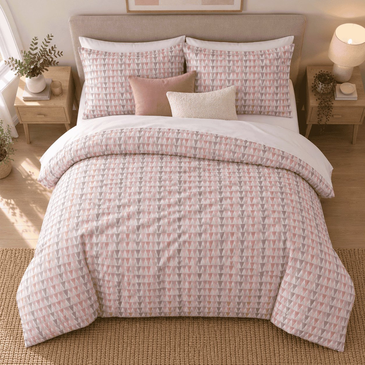 Blush Grey Triangle duvet cover set, overhead view showing the full bed on a jute rug with pale oak bedside tables