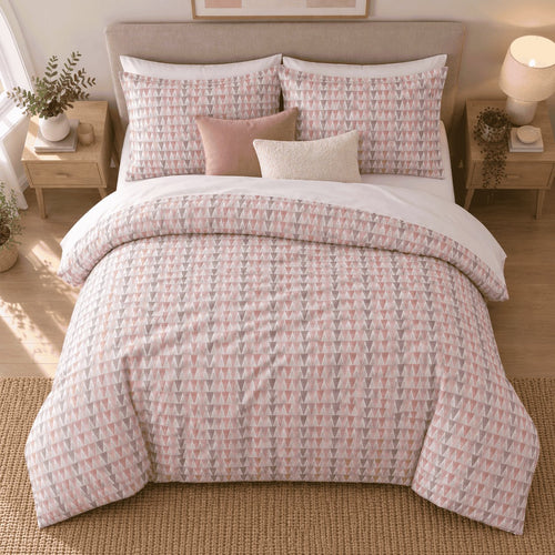 Blush Grey Triangle duvet cover set, overhead view showing the full bed on a jute rug with pale oak bedside tables
