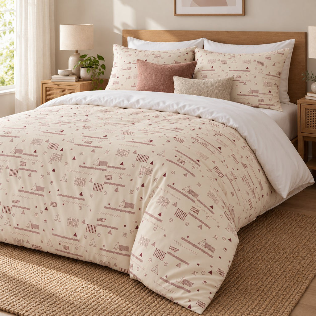 Cream Rose Retro Geometric duvet cover set, angled view showing the retro print draped over the bed end onto a jute rug
