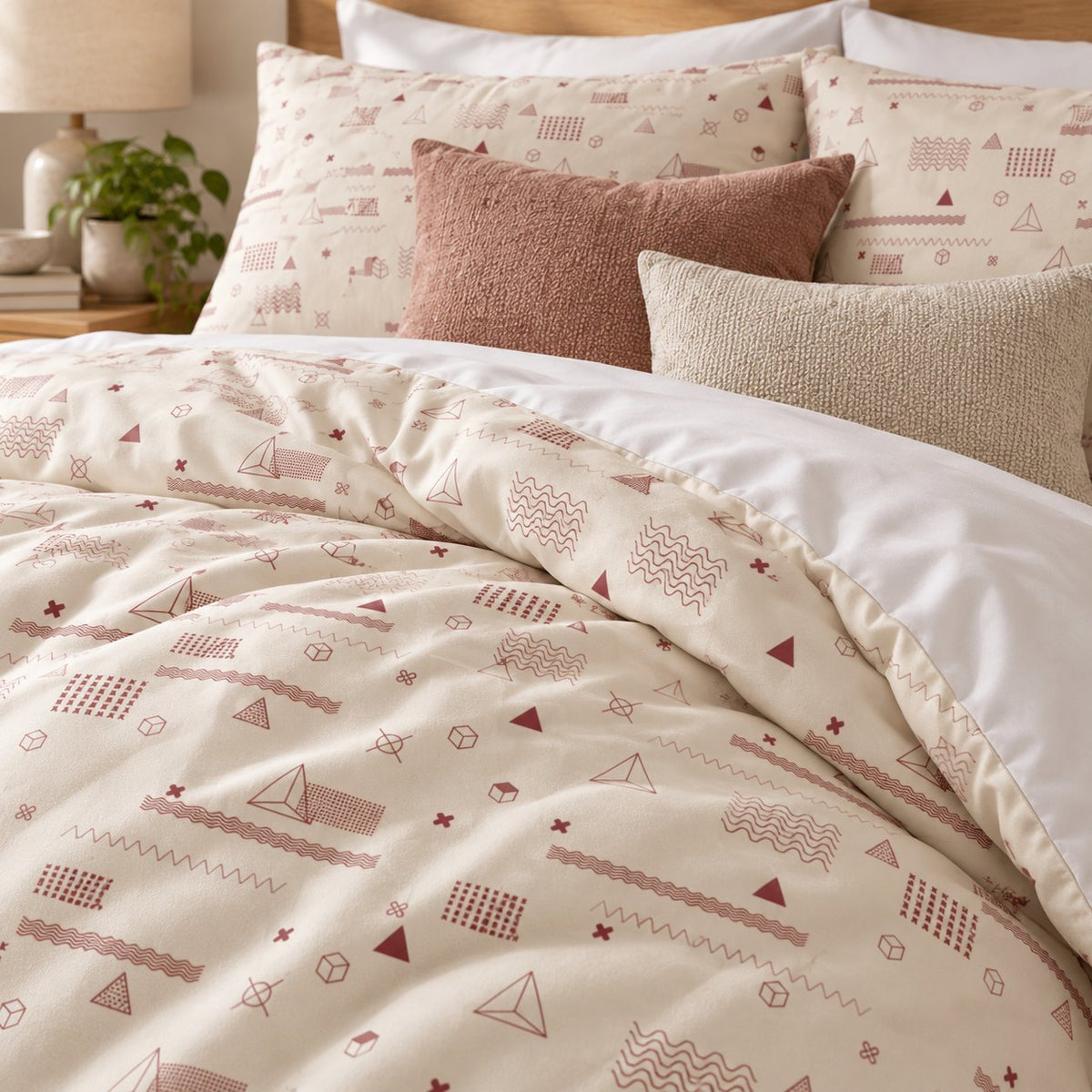Cream Rose Retro Geometric duvet cover set, close-up of pillowcases showing pillowcases behind terracotta and oatmeal bouclé
