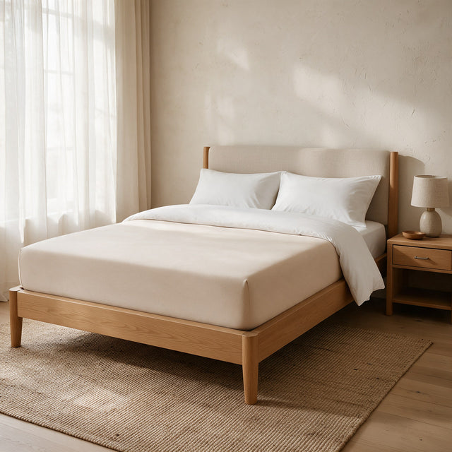Beige Extra Deep Fitted Sheet on a deep mattress in an oak bed, duvet folded back