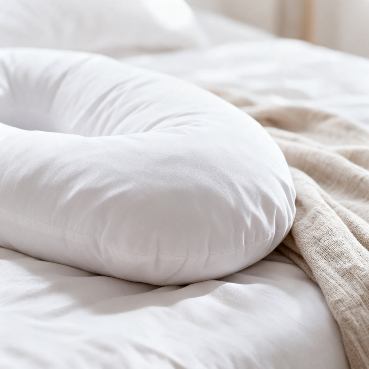 Close-up of the rounded end of the Maternity Body Pillow showing its soft white cover and plump fill