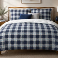 Midnight Plaid duvet cover set, front view showing navy squares framed by white and sky-blue bands on a walnut bed