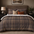 Mocha Plaid duvet cover set, front view showing grey-brown check with caramel bands and cream lines on a studded bed
