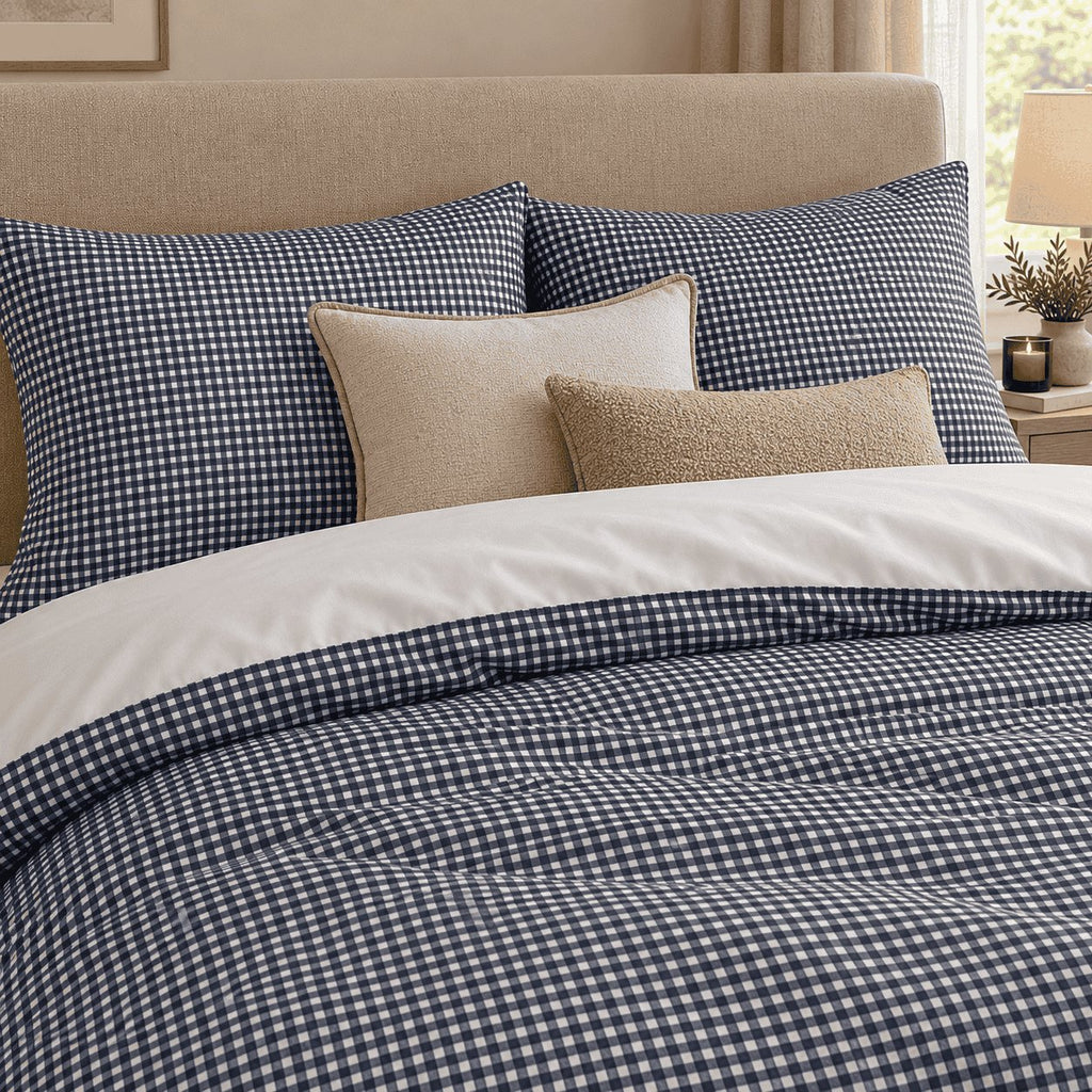 Navy Gingham duvet cover set, close-up of pillowcases showing navy gingham pillowcases behind cream and sand cushions
