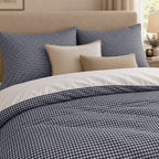 Navy Gingham duvet cover set, close-up of pillowcases showing navy gingham pillowcases behind cream and sand cushions