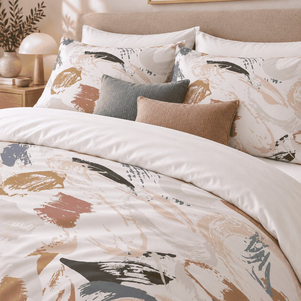 Neutral Brushmark Abstract duvet cover set, close-up of printed pillowcases with charcoal and terracotta cushions